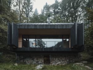 Une maison en bois s'insère délicatement dans une forêt de République tchèque